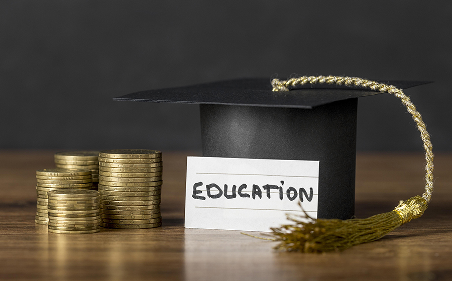 A graduation cap and stacks of coinsDescription automatically generated